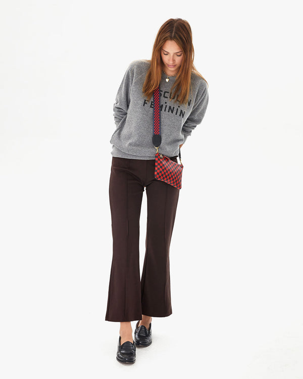Aurelia wearing the Red & Navy Checker Wallet Clutch with Tabs with the Navy & Red Checker Crossbody Strap.  she's also wearing the chocolate le flair pants and the grey masculin feminin sweatshirt