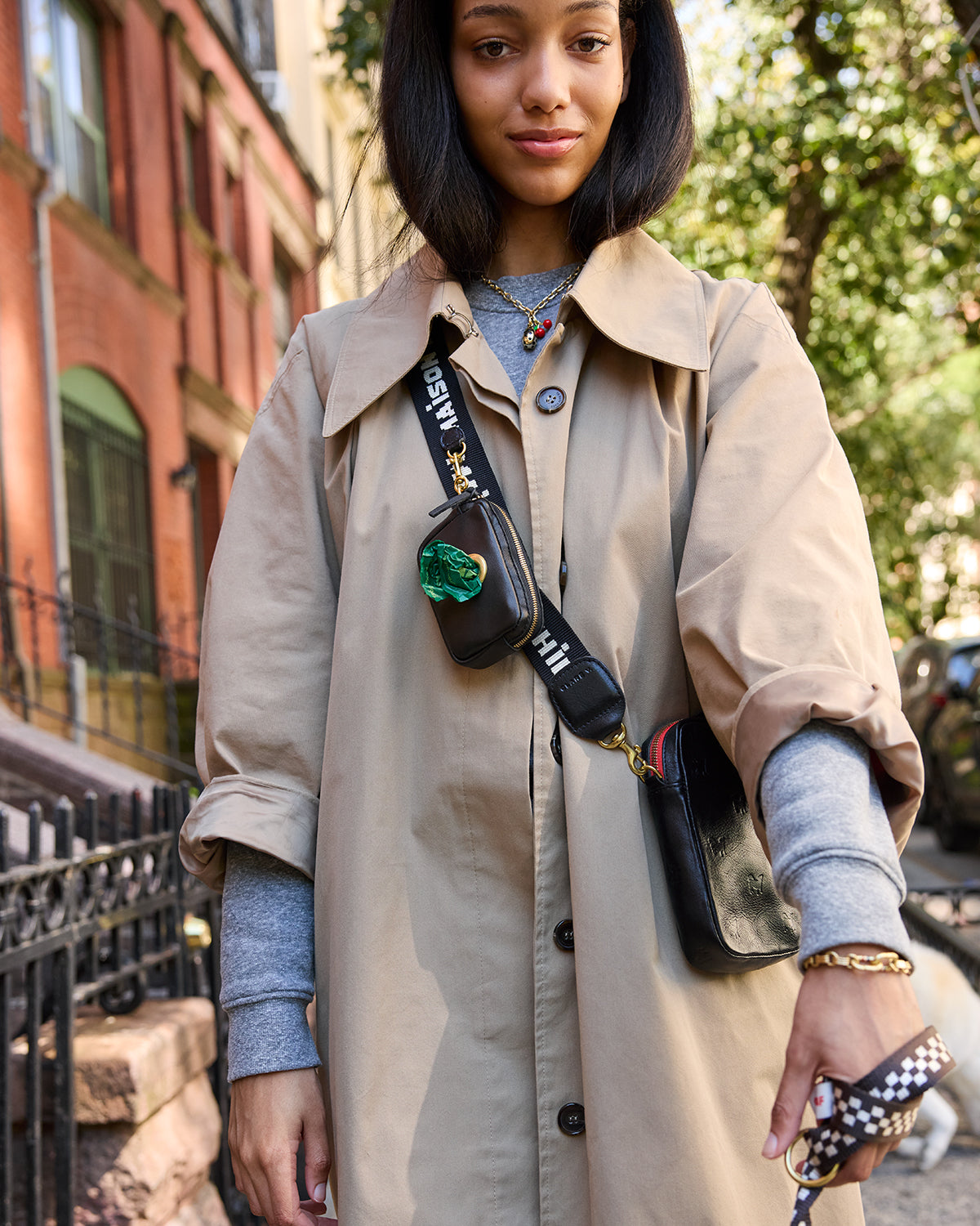 Close-up of model wearing the Clare V. x The Dogist Le Sportif where you can see poop bags poke through the pouch that's connected to the strap. 