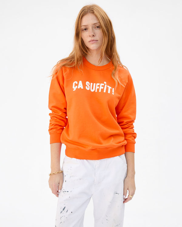 Haley is wearing the ÇA SUFFIT! sweatshirt in bright neon orange