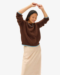 Maly with her arms above her head in the Chocolate Elsa Sweater