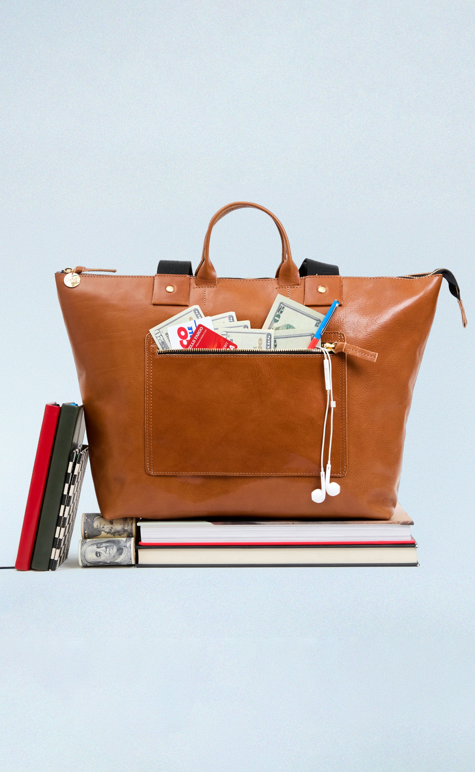 Miel Le Zip Sac with exterior pocket unzipped with cash and cards sticking out.