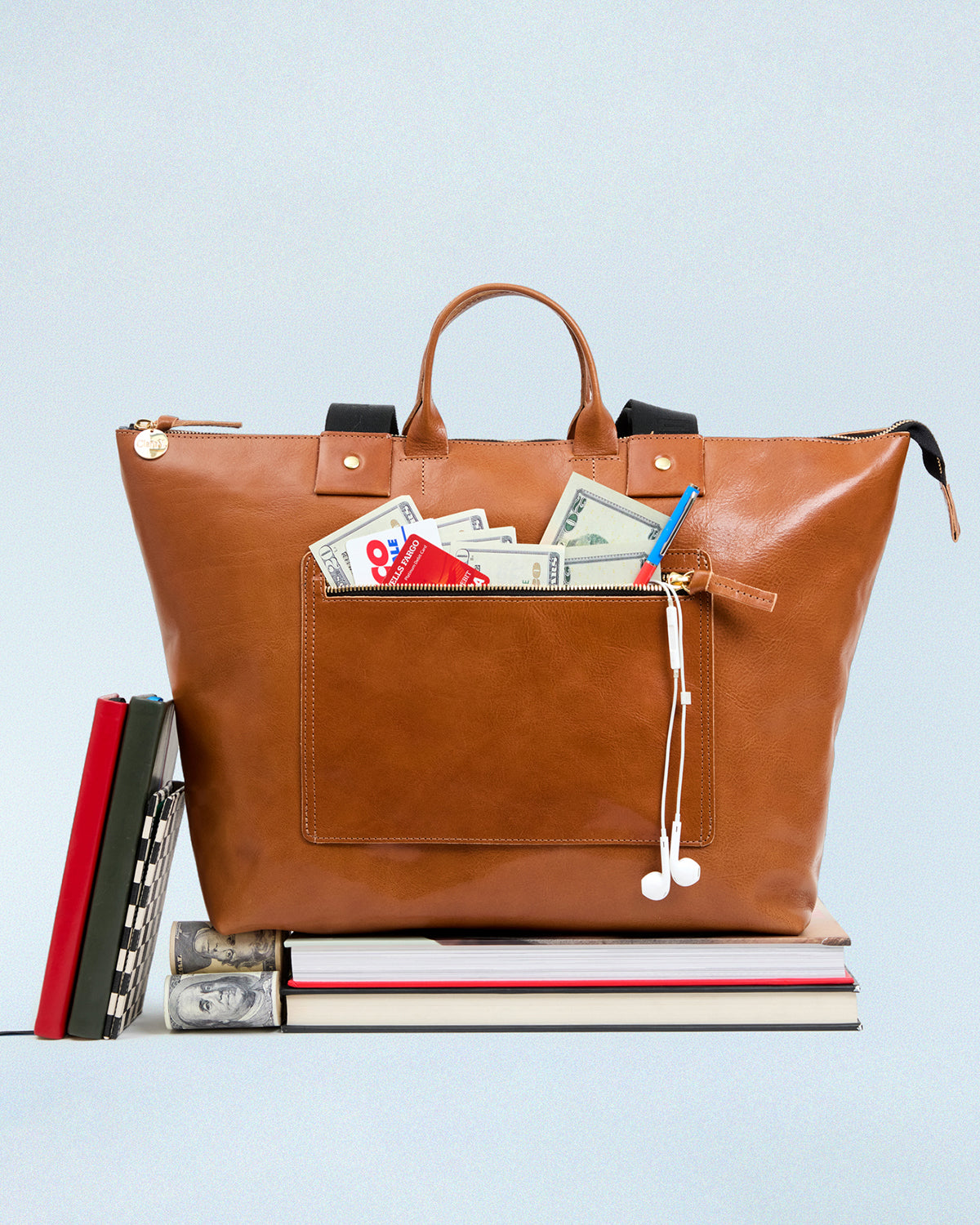 Miel Le Zip Sac with exterior pocket unzipped with cash and cards sticking out.