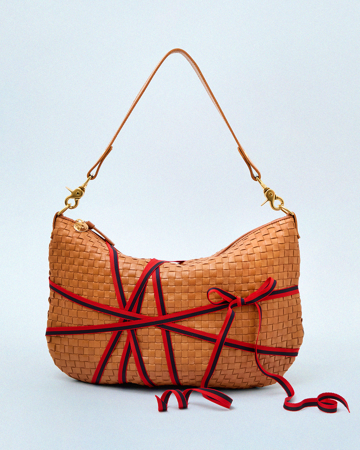 Natural Woven Checker Moyen Messenger with Ribbon tied around it to mark it as a gift. 