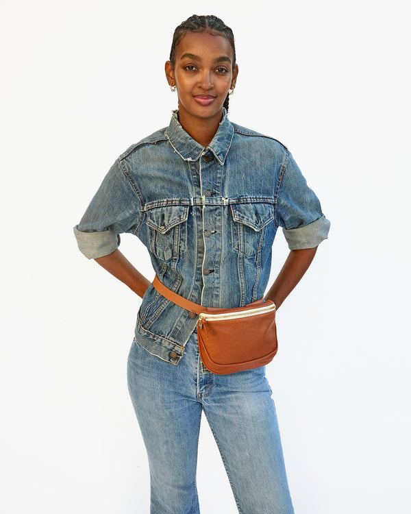 Jordan wears the tan neptune fanny pack as a belt bag around her waist