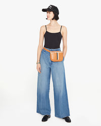 Athena wears the natural rustic fanny pack with black and white stripes around her waist