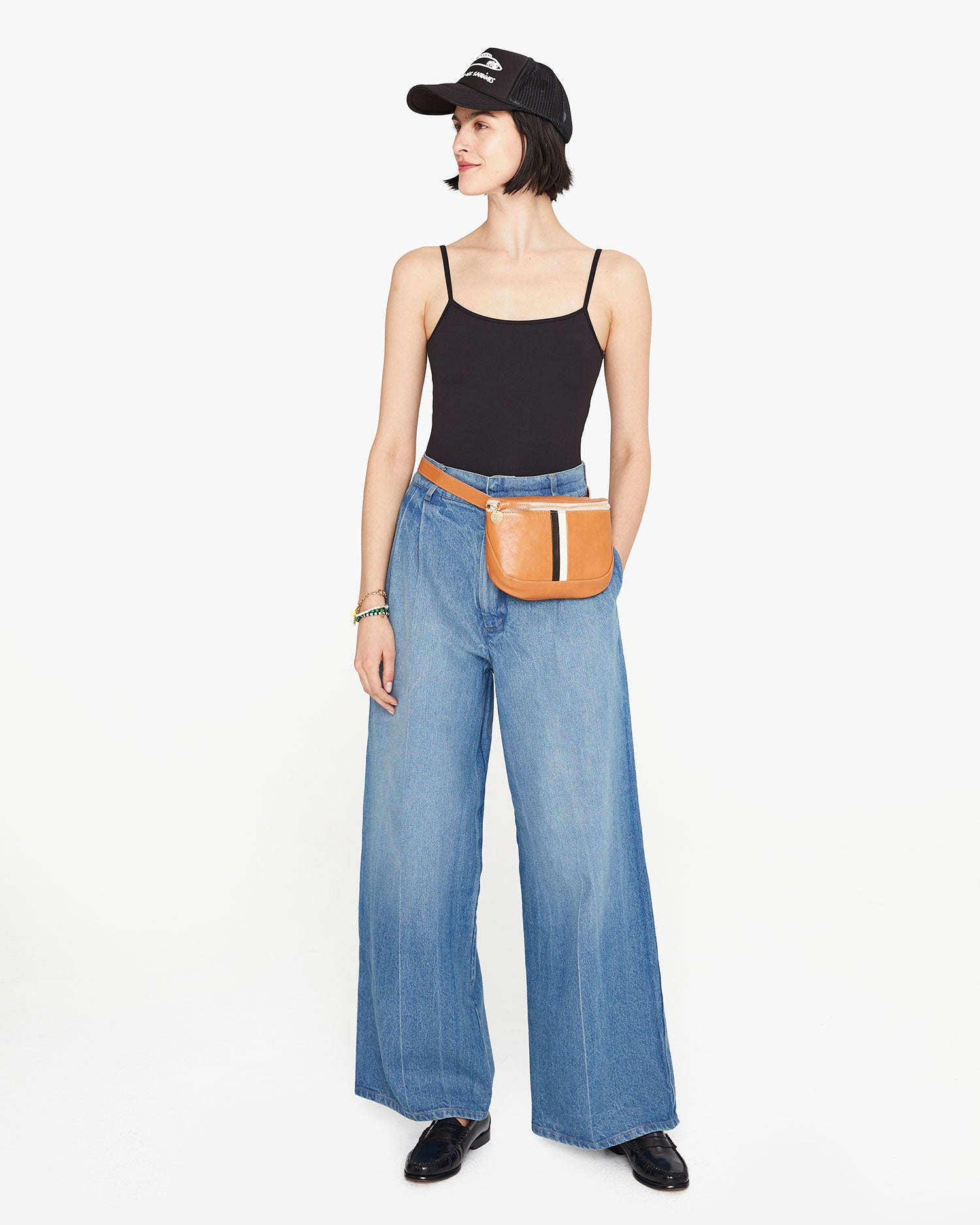 Athena wears the natural rustic fanny pack with black and white stripes around her waist