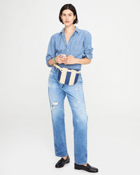 athena wearing the Indigo & Cream Woven Racing Stripes Fanny Pack with jeans, a denim shirt and black loafers
