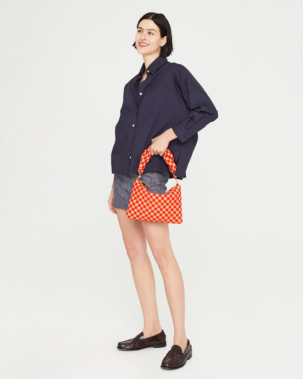 athena carrying the poppy and khaki checker flat clutch with tabs by the Poppy & Khaki Checker Twisted Puff Top Handle