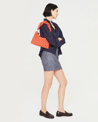 athena carrying the poppy and khaki checker flat clutch with tabs with the Poppy & Khaki Checker Twisted Puff Top Handle