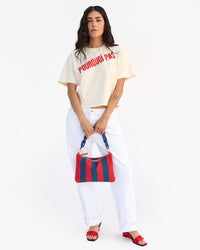 Gia holds Flat Clutch w Tabs in front of her with both hands