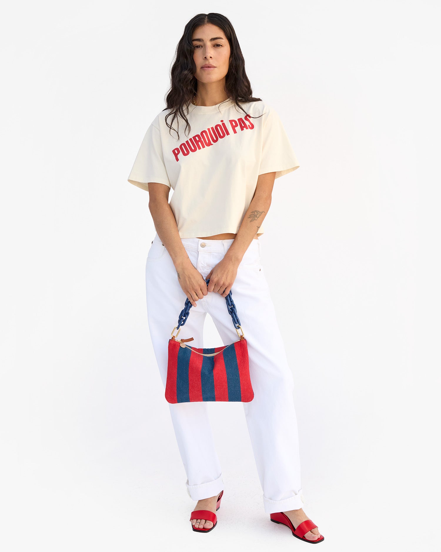 Gia holds Flat Clutch w Tabs in front of her with both hands