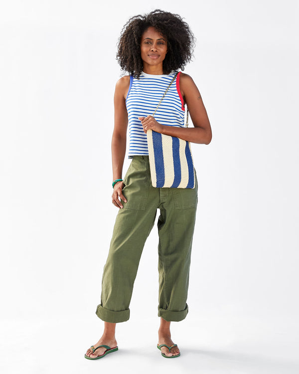 Mecca wearing the Indigo & Cream Woven Racing Stripes Foldover Clutch w/ Tabs with a chain shoulder strap