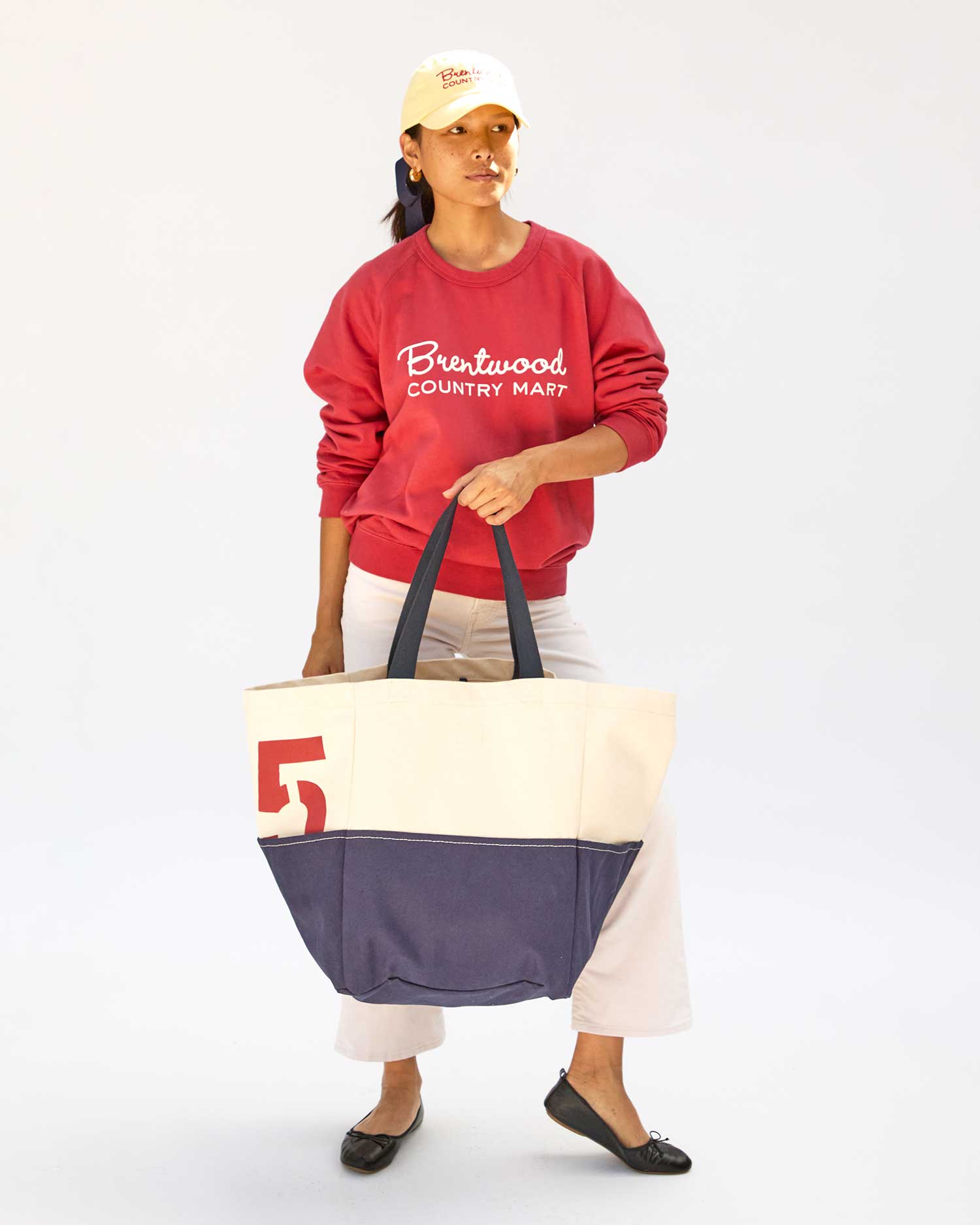 Maly holding the Natural & Navy Canvas w/ Brentwood Red 75 Giant Marine in front of her body by her left hand