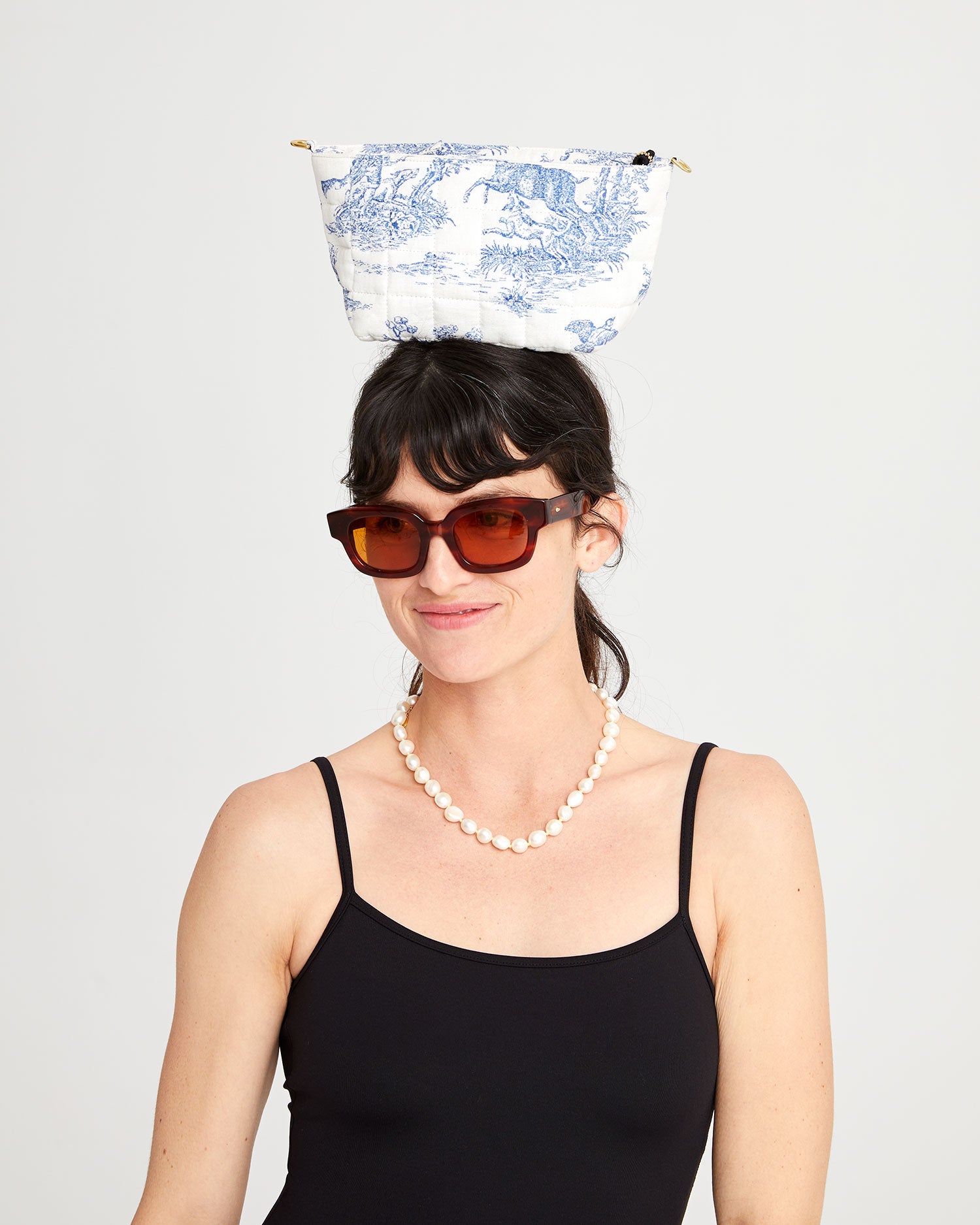 Danica with the St. Calais Blue Quilted Linen Toile Pochette on top of her head.
