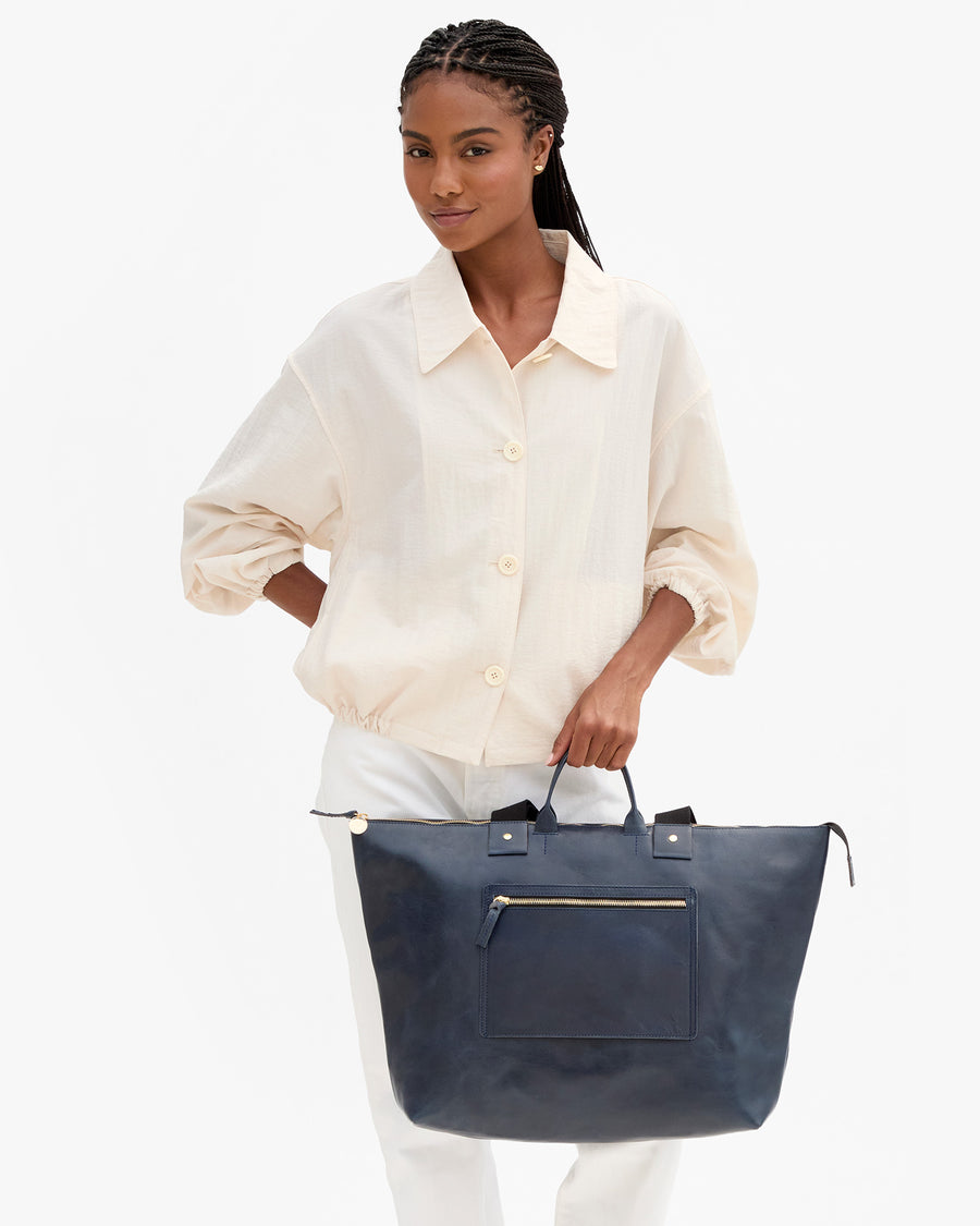Vitoria holds Grand Zip Sac in Twilight by the top handle