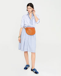 Athena is wearing the Grande Fanny in Cuoio Perf at her waist.