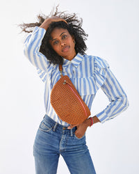 Mecca wears the Tan Rattan Grande Fanny as a cross-body.