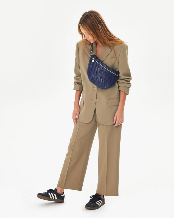 Aurelia wearing the Pacific Woven Zig Zag Grande Fanny cross body over a tan suit