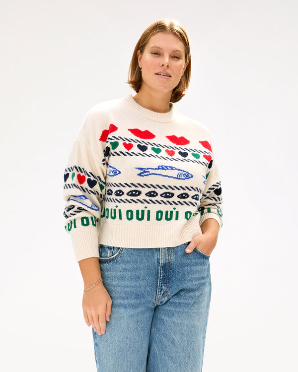 Sonnie wearing the Cream w/ Multi Icon Intarsia Icon Sweater with high waisted jeans and her hand in her pocket