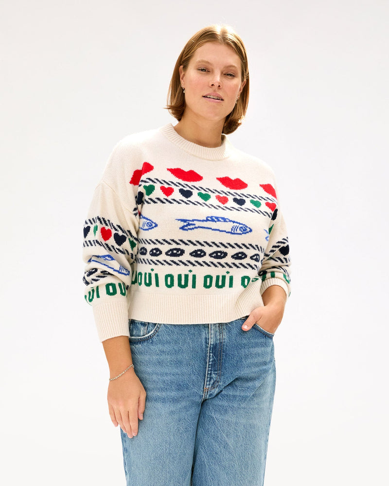 Sonnie wearing the Cream w/ Multi Icon Intarsia Icon Sweater with high waisted jeans and her hand in her pocket