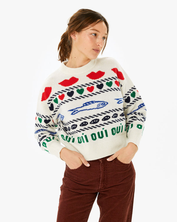 Zoe wearing the Cream w/ Multi Icon Intarsia Icon Sweater with brown pants