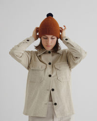 Model wearing the Plain Hat Contrast Pompom in Cumin and Black
