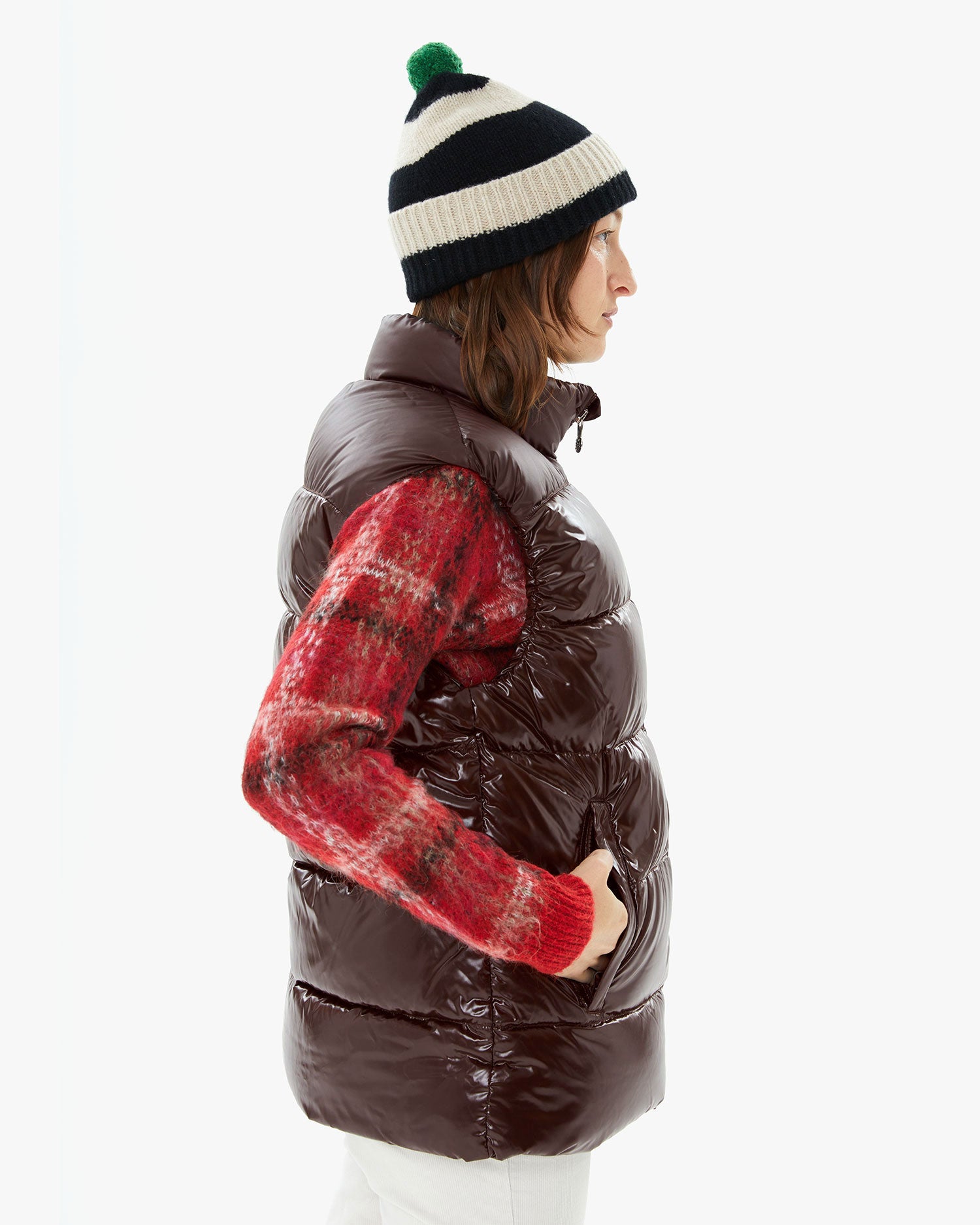 Model wearing the Stripe Pompom Hat in Black and Oatmeal with a puffy vest