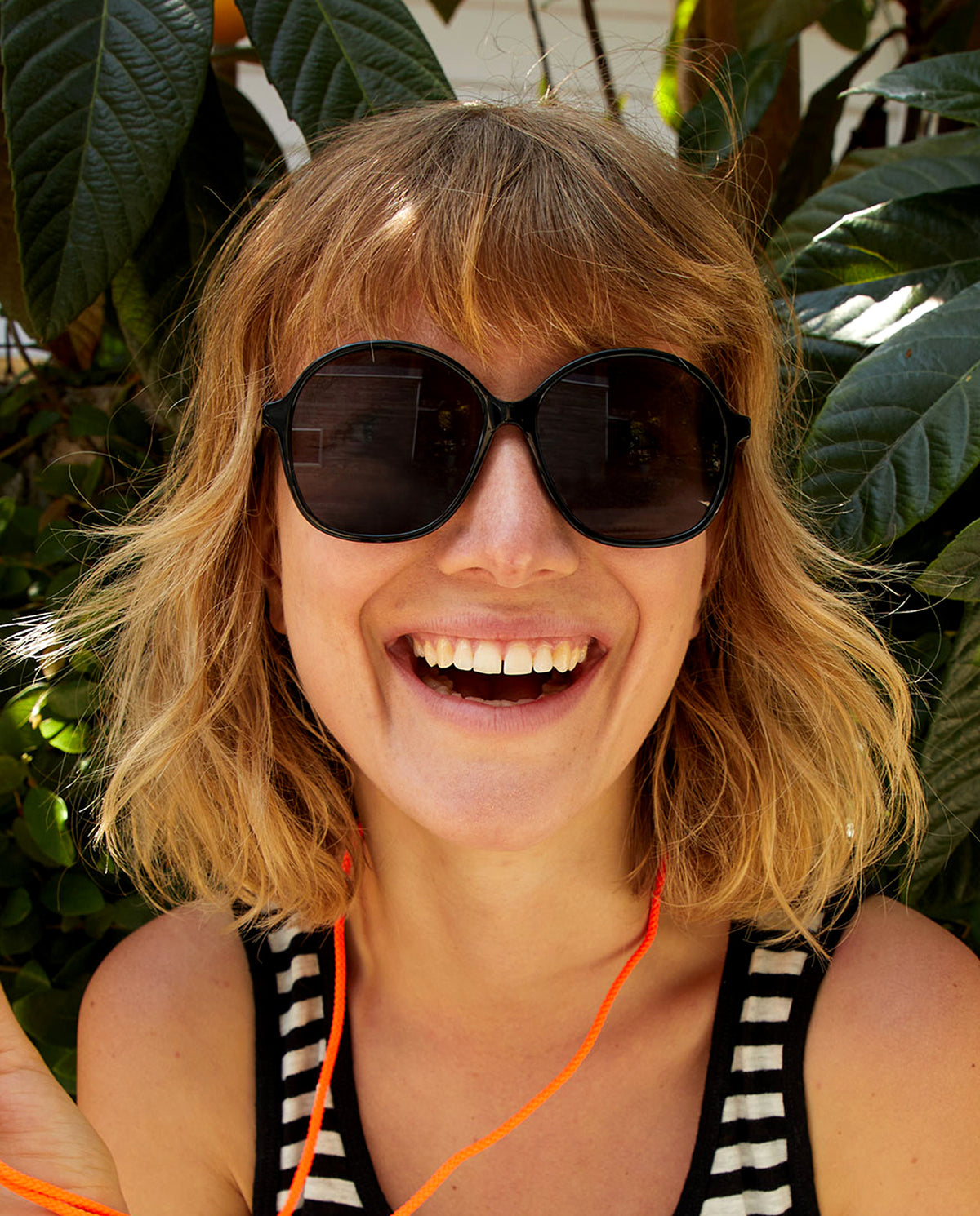 Lou wearing our Black Jane Sunglasses and smiling. 