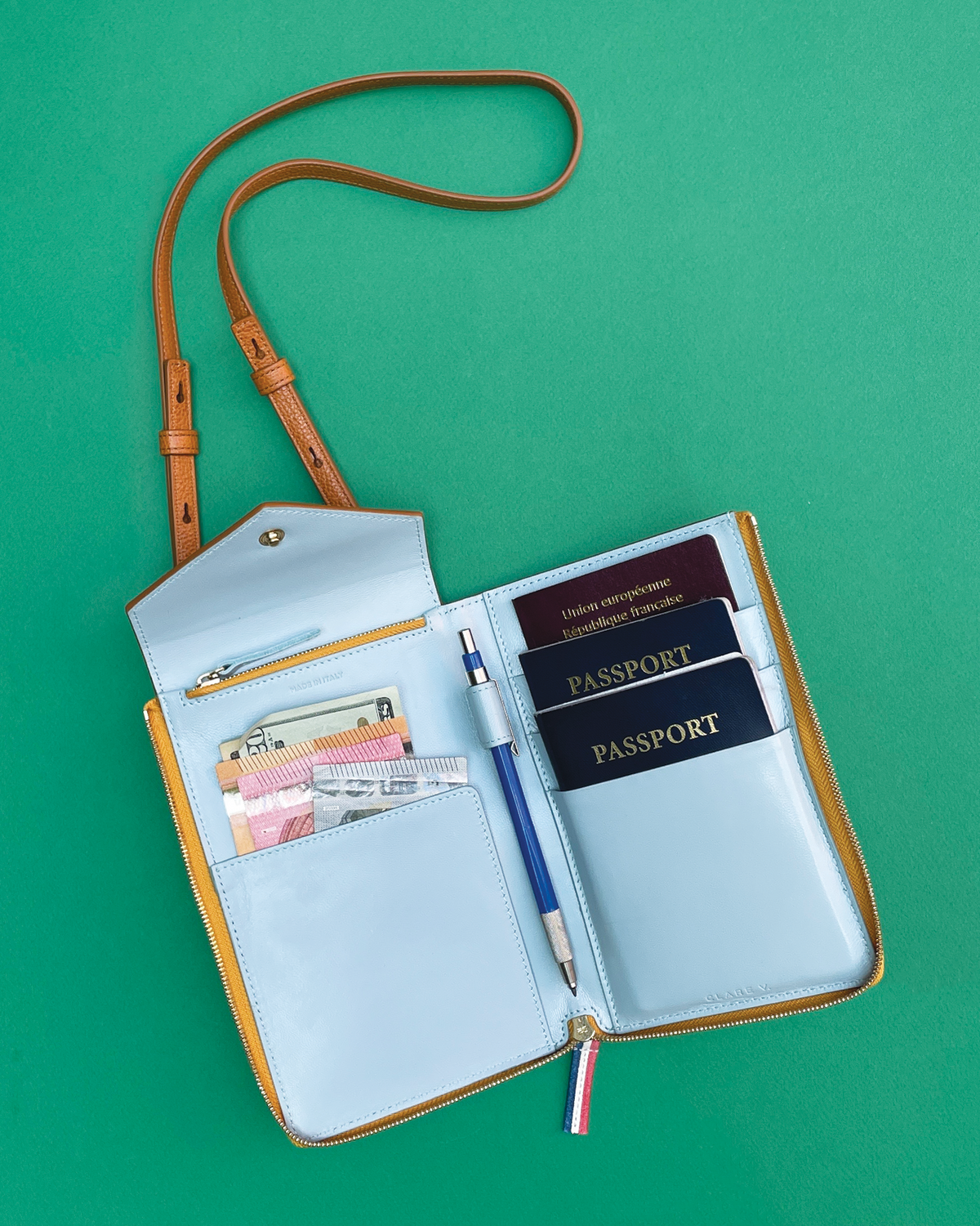 Jimmy Kimmel's Passport Case full of money and passports and a pen.