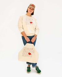 Sonnie wearing the Tan Corduroy w/ Liberte Egalite Maternite Baseball Hat with the EMC Sweatshirt and carrying the matching EMC Jumbo Tote.