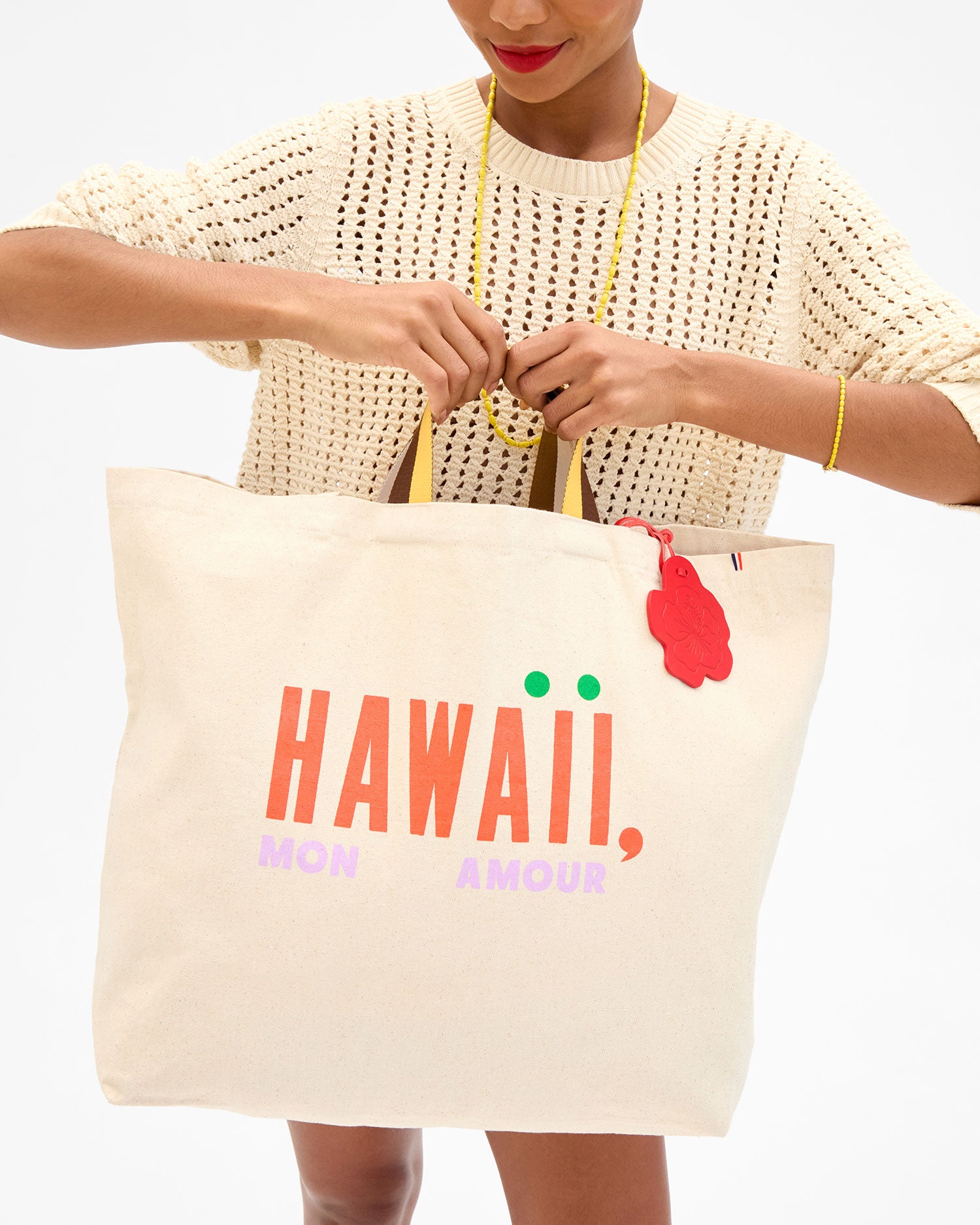 Model holding the Hawaii, Mon Amour Jumbo Tote by the top handles. 
