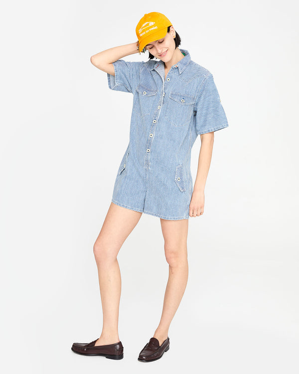 athena wearing the Engineer Stripe Jumpsuit Cargo with loafers and the marigold liberez les sardines baseball hat