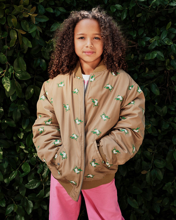 Model wearing the Khaki Kids Bomber over pink pants with her hands in the pockets