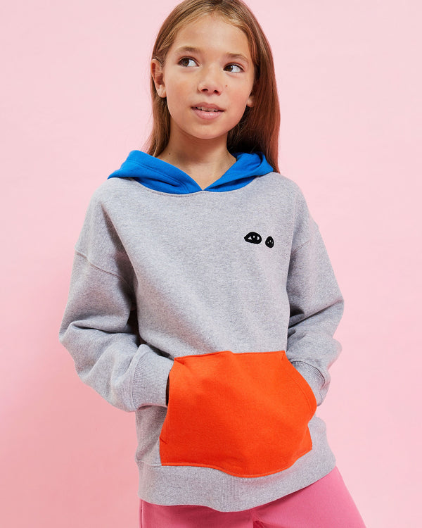 model wearing the Grey w/ Poppy & Cobalt Kids Hoodie with her hands in the front pocket