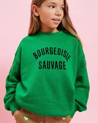 model wearing the Green w/ Black Bourgeoisie Sauvage Kids Sweatshirt with the khaki kids pants