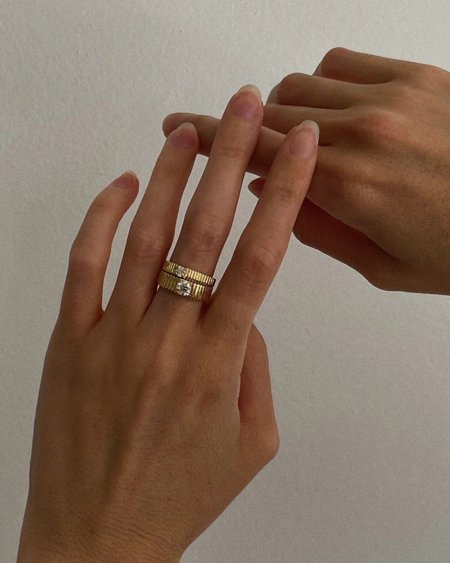 model wearing Kinn Studios Mini Solis Ribbed II Ring with another Kinn ring