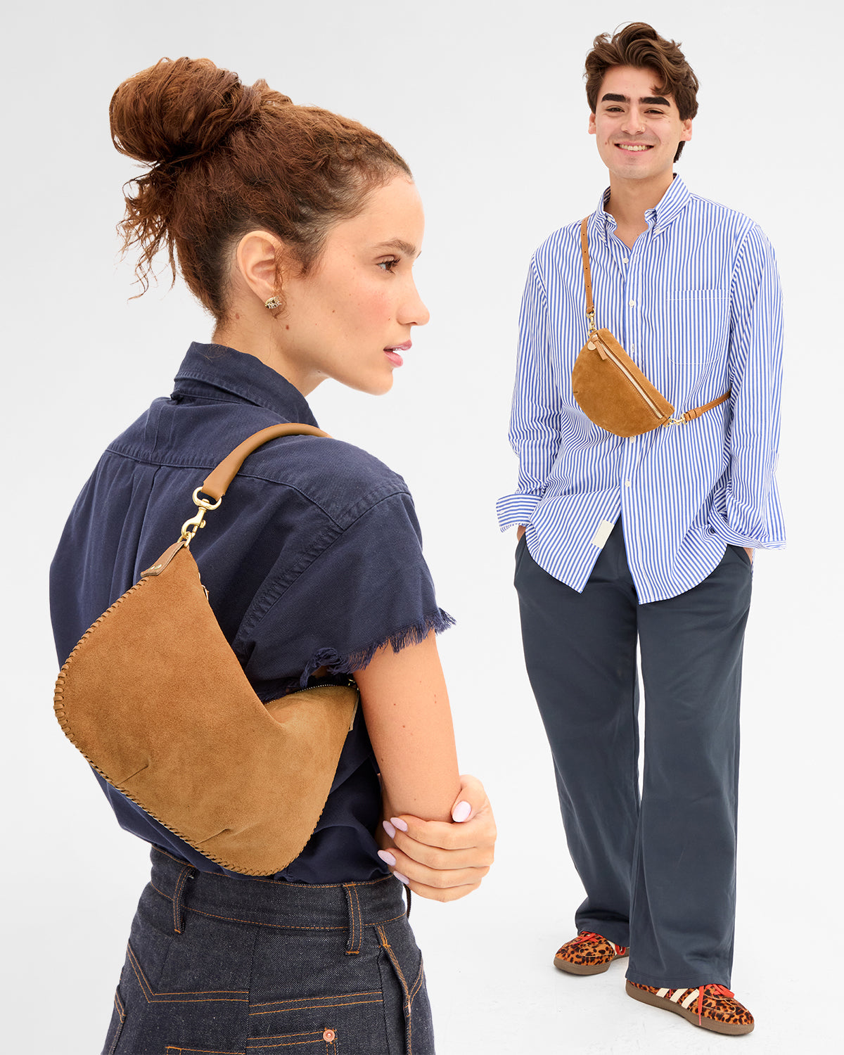 Woman carrying the Caramel Suede Petite Moyen and man carrying the Caramel Suede Petite Fanny across his chest. 