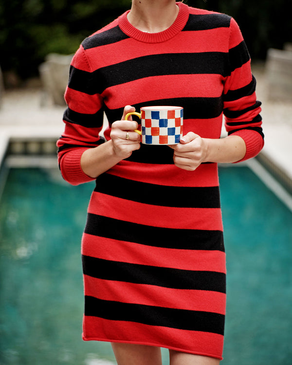 Zoe wearing the Black & Poppy Stripe Long Sleeve Dress and holding the a checkered mug