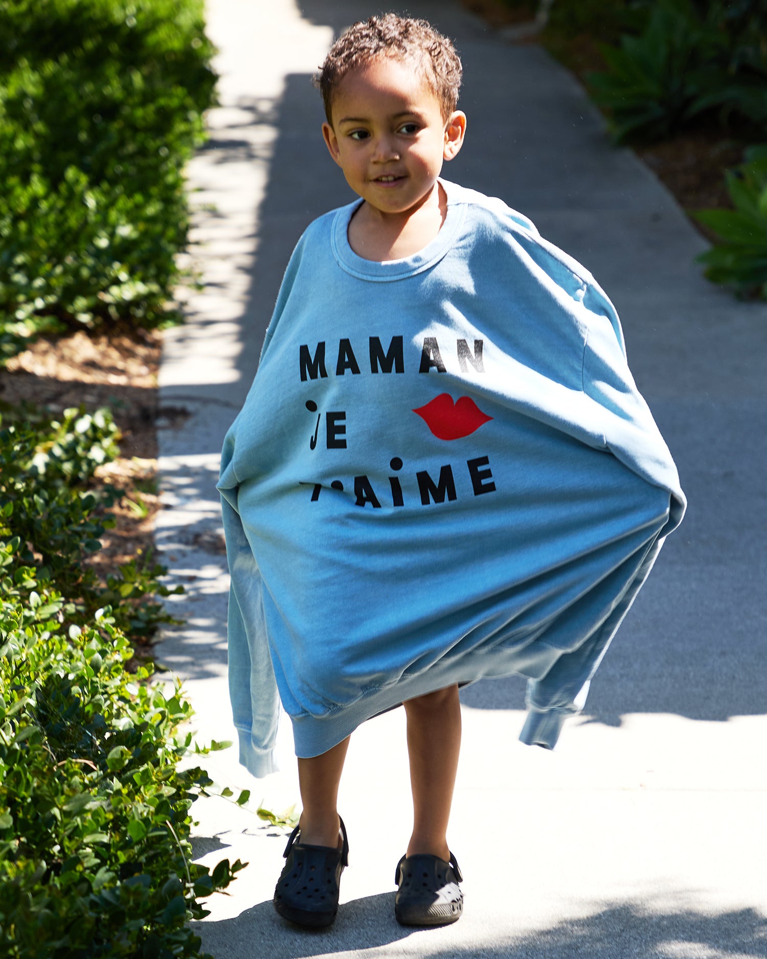 Child wearing the blue Maman Je T'aime Sweatshirt. 