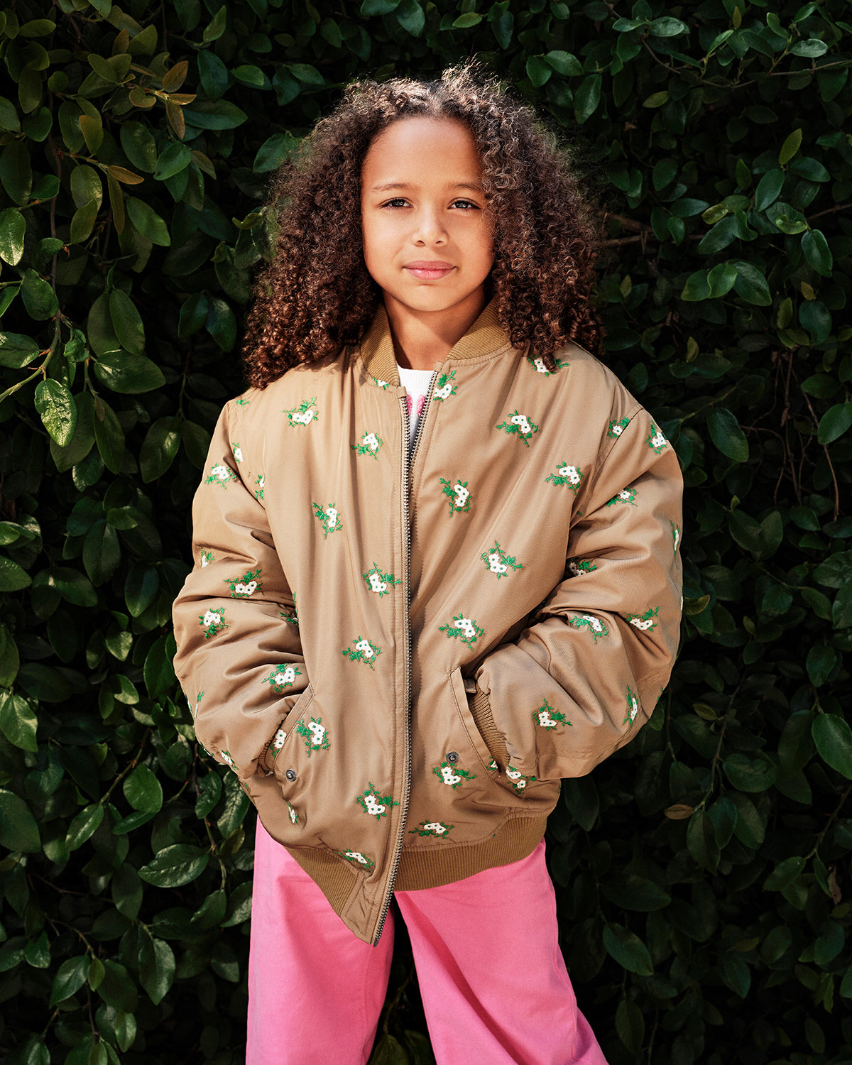 Model wearing the Khaki Kids Bomber over pink pants with her hands in the pockets
