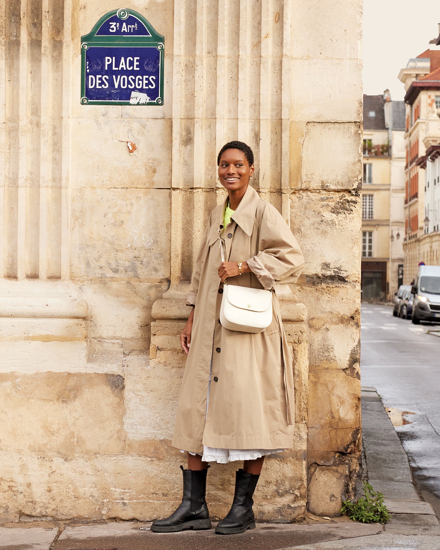 Model posing in front of a building and carrying the Cream Turnlock Louis 