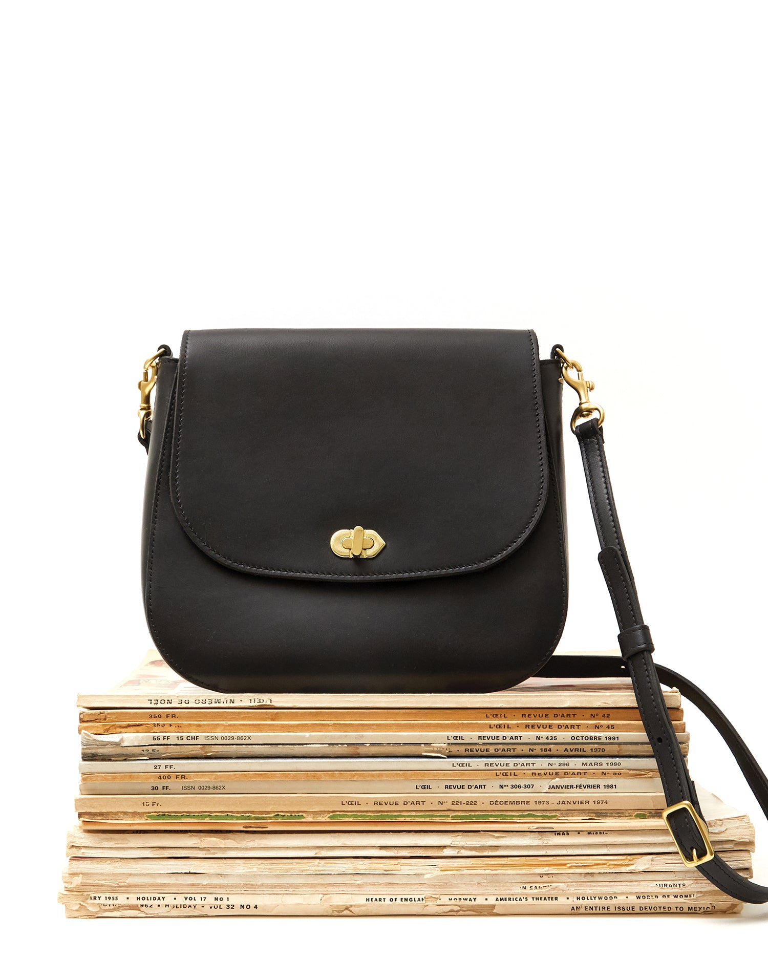 Black Turnlock Louis sitting on top of old magazines. 