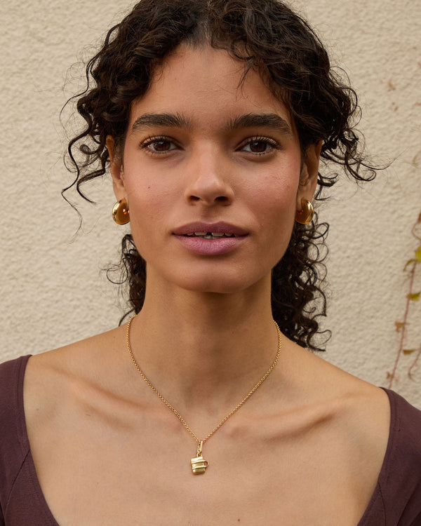 Haro wearing the La Tropezienne Gold Charm on the rolo chain necklace