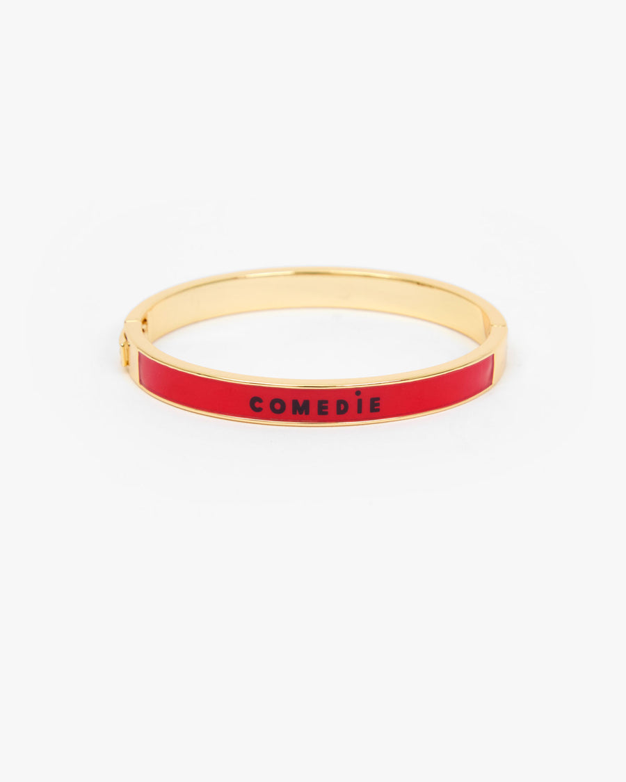 Le Bangle Bracelet with a vibrant red enamel inlay and the word 'COMEDIE' printed in black on the front.