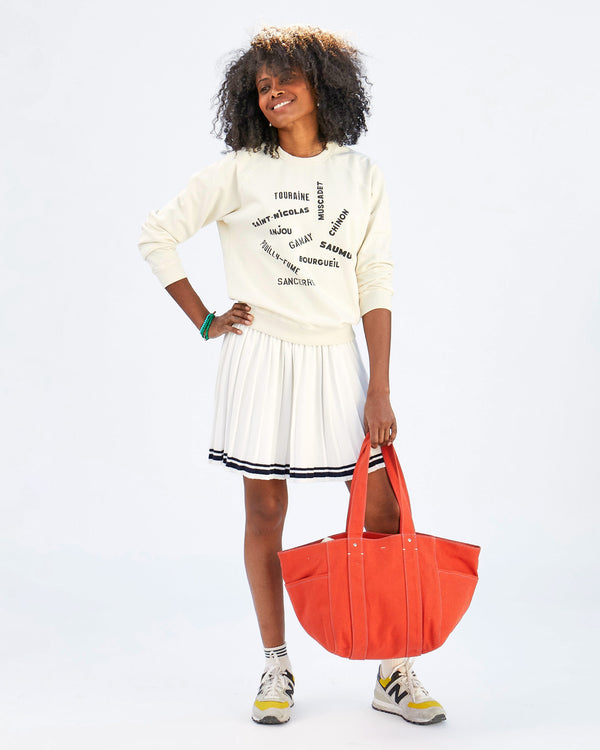 mecca holding the Poppy Canvas Le Box Tote in front of her legs with her hand on her hip