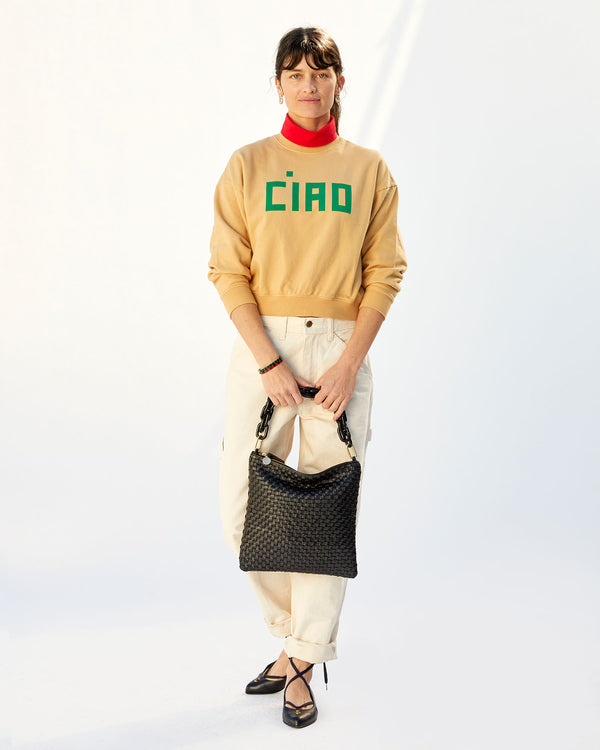 danica in the oat le drop and cream jeans . she's holding the Black Woven Checker Foldover Clutch w/ Tabs by the black resin shortie strap in front of her legs