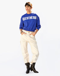 Danica in white pants and black boots with the Cobalt Discothèque Le Drop