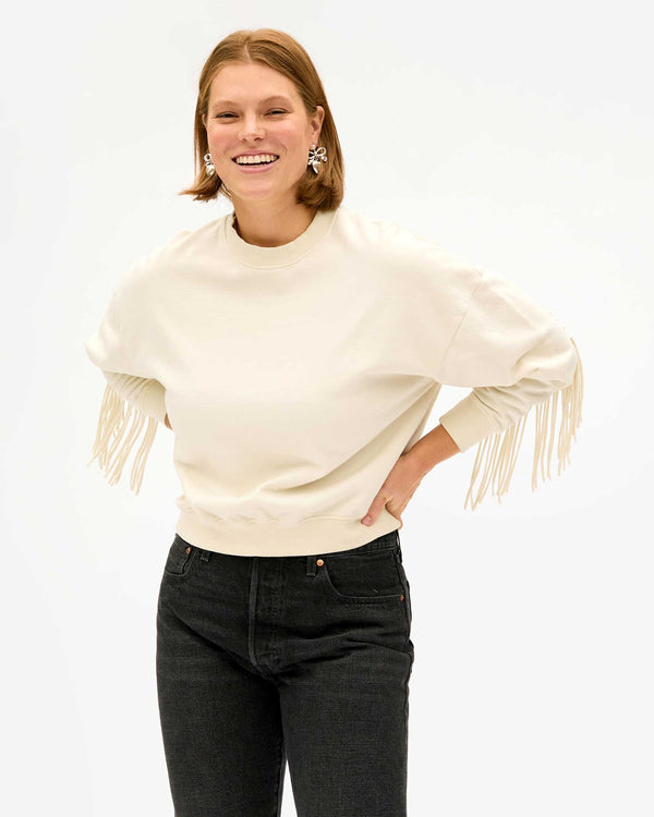 Sonnie wearing the Cream Le Drop Fringe with black jeans. she has her hands on her hips
