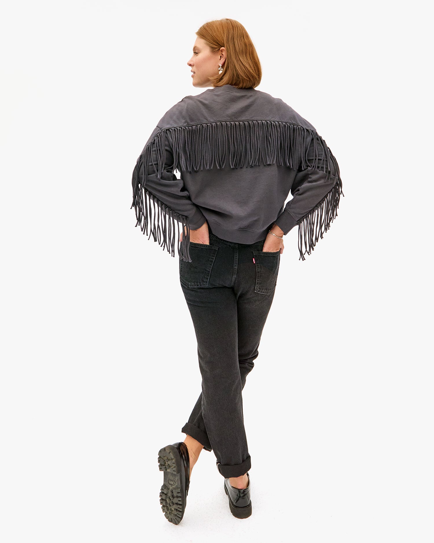 Back view of sonnie wearing the charcoal le drop fringe with black jeans 