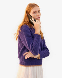 Haley holds the Black Oui Leather iPhone Case to her ear to take a call